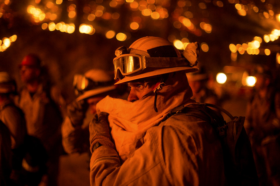 Un bombero se cubre el rostro mientras lucha contra el fuego cerca de San Andreas, California.