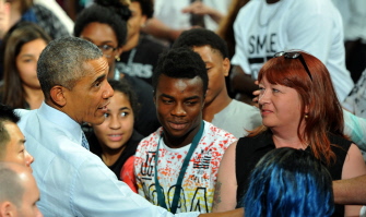 Obama saluda a los asistentes al encuentro en la North High School en Des Moines, Iowa