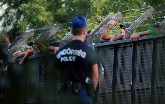 Policías húngaros hacen guardia ante la valla metálica en la autopista M5, para bloquear el paso de migrantes en la frontera con Serbia, en Röszke 