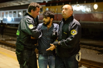 Policías eslovenos arrestan a un emigrante que intentaba subirse a un tren en la estación ferroviaria, en Dobova, cerca de la frontera con Croacia