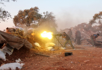 Un rebelde dispara artillería durante choques con las fuerzas gubernamentales y milicianos shabiha en las afueras de Idlib 