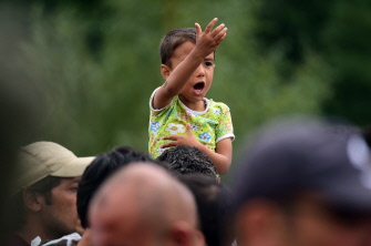 Un niño emigrante, sentado en los hombros de su padre en la frontera austro-húngara de Heiligenkreuz, Austria, antes de partir hacia Alemania