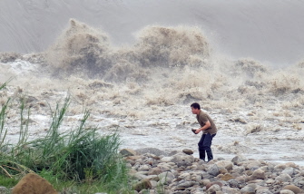 Un residente local recoge piedras del río Xindian después del paso del tifón Dujuan en la Nueva Taipei, en Taiwán