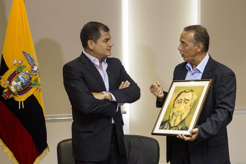 Rafael Correa (i) recibe un cuadro de Fidel Castro por parte del ex agente cubano que estuvo preso en EU, Antonio Guerrero (d)