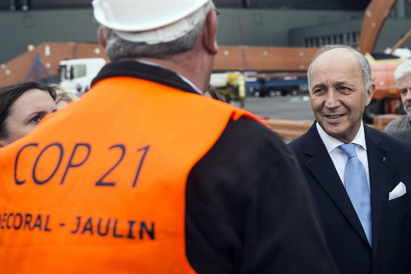 El ministro francés de Exteriores, Laurent Fabius (d), conversa con trabajadores ayer en el aeropuerto Le Bourget, en el norte de París