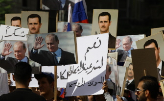 Cientos de manifestantes con retratos del presidente sirio Asad y su par ruso Putin muestran su apoyo a Moscú ante la embajada rusa en Damasco