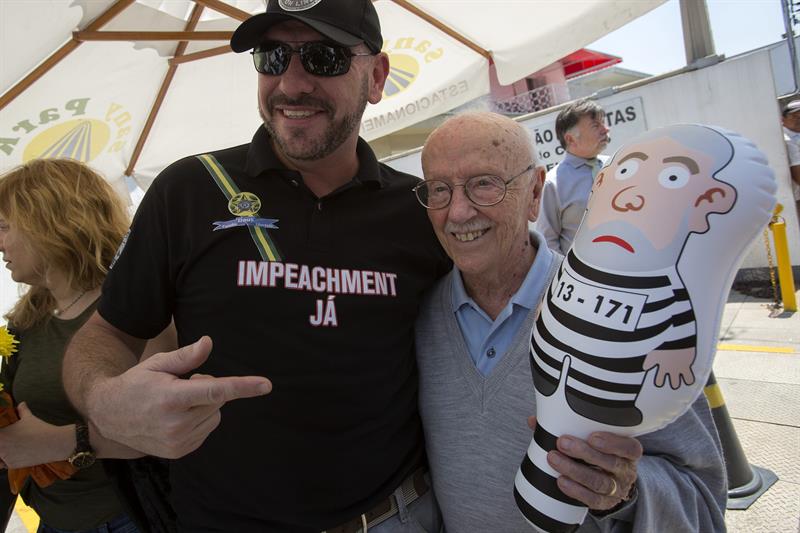 Helio Bicudo (d) se toma una fotografía con un hombre que le regala un muñeco con la imágen de Lula en traje de presidiario, hoy en Sao Paulo