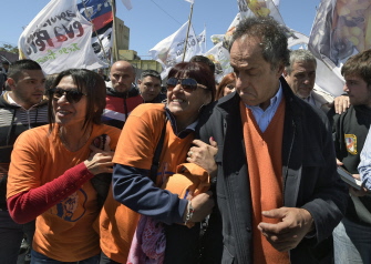 El gobernador de Buenos Aires y candidato oficialista, Daniel Scioli (d), hace un gesto de sorpresa  al ser agarrado por seguidores en Avellaneda