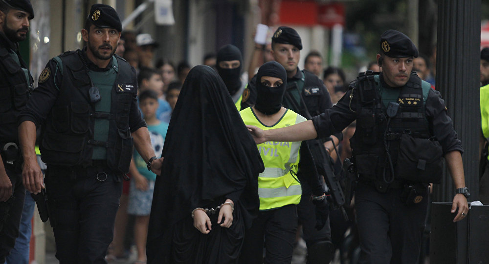 En esta imagen de archivo puede verse a policías españoles con una mujer detenida por su relación con el yihadismo