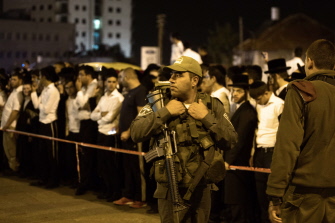 Agentes de seguridad israelíes hacen guardia junto al cadáver de un israelí muerto al ser confundido con un terrorista palestino en un autobús