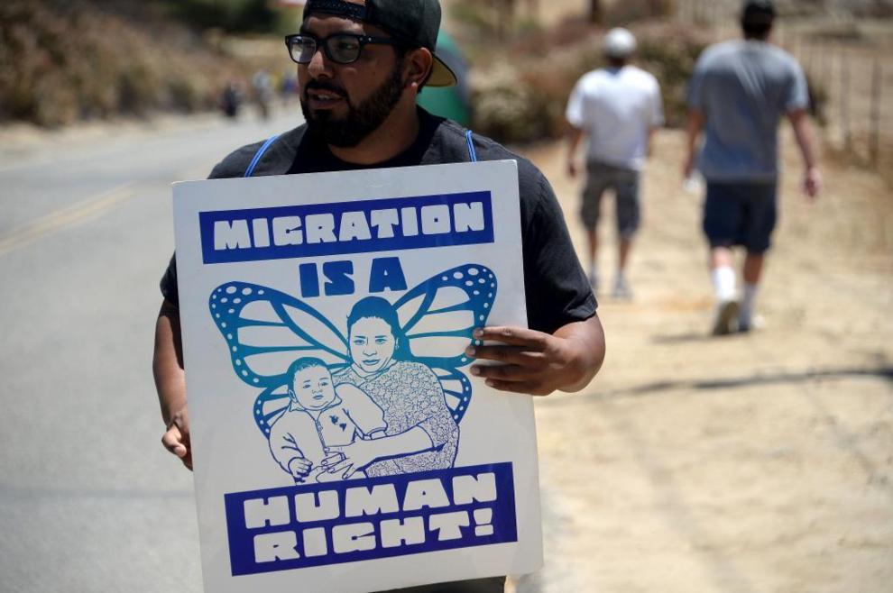 Un manifestante sostiene un cartel de apoyo a la migración durante una protesta en Murrieta, California