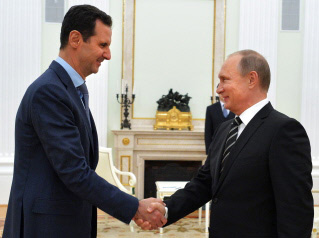 El presidente ruso, Vladimir Putin (d), da la mano a su par sirio, Al Asad (i) durante su encuentro del martes en el Kremlin, en Moscú
