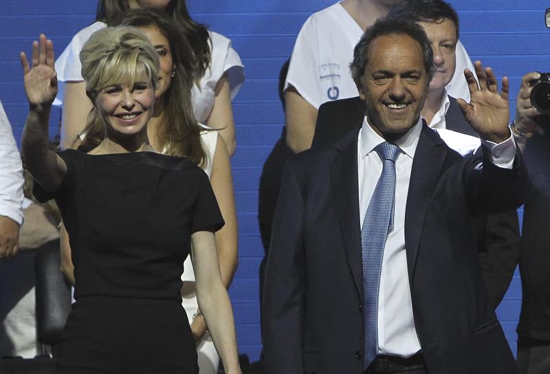 El candidato oficialista Daniel Scioli (d), y su esposa Karina Rabolini (i), en el acto de cierre de campaña, hoy en el Luna Park de Buenos Aires