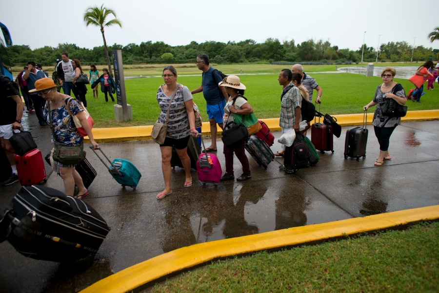 En Puerto Vallarta se formó una fila de turistas para abordar los autobuses que los llevaron a un refugio.