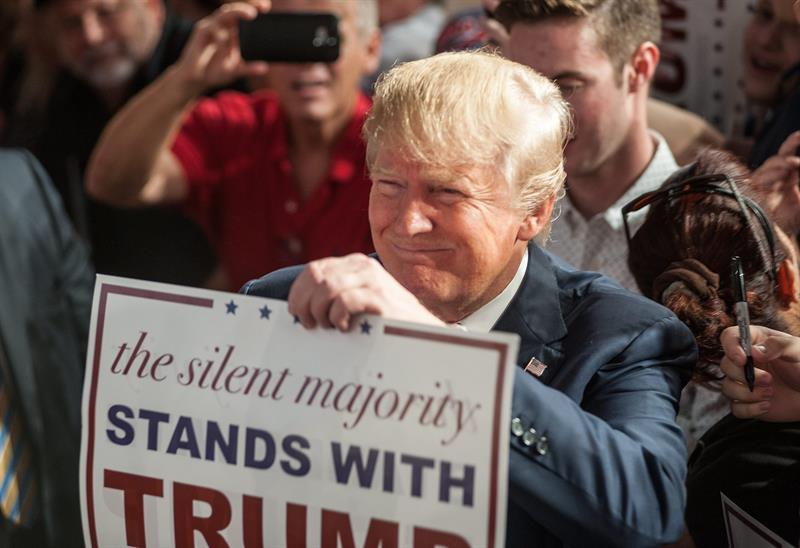 "La mayoría silenciosa, con Donald Trump", dice el cartel que sostiene el aspirante republicano en un reciente mitin