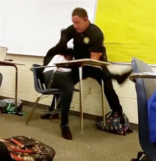 En esta imagen de video puede verse un momento del forcejeo entre el agente policial y la alumna en la clase