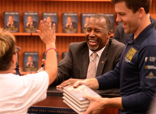 Ben Carson sonríe y saluda a residentes durante su evento de firma de libros en Lake Sumter Landing, The Villages, en Florida