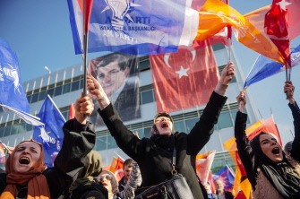 Varias simpatizantes del partido gubernamental ondean banderas turcas al llegar el primer ministro Ahmet Davutoglu al aeropuerto de Estambul