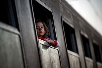 Una niña migrante mira desde un tren en la estación de la ciudad serbia de Sid