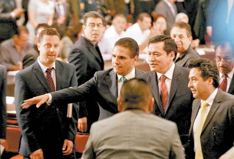 El mandatario michoacano con el titular de Segob (centro) durante el acto en el Palacio de Gobierno en Morelia.