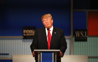 Donald Trump reacciona con una mueca ante una crítica de la aspirante Carly Fiorina durante el debate