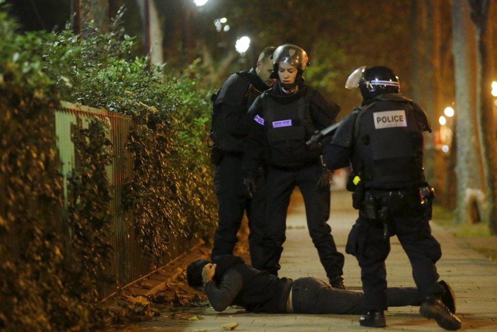 La policía francesa comprueba la identidad de un hombre cerca de la sala de concierto Bataclan, donde se reportó la toma de rehenes; finalmente fue pu