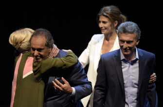 Daniel Scioli (2i) es felicitado por su esposa, Karina Rabolini (i) mientras Macri (d) y su mujer, Juliana Awada (2d), se retiran tras el debate