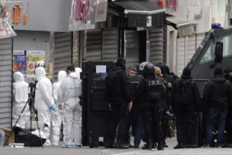 Forenses de la policía francesa y miembros del BRI, unidad especial policial, junto al edificio que fue escenario del tiroteo con los yihadistas