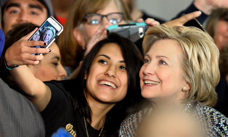 Hillary Clinton (d) posa con una seguidora durante un acto de campaña hoy en Mountain View College en Dallas 