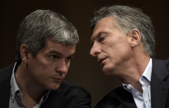 Mauricio Macri (d) habla con su jefe de campaña, Marcos Peña (i), durante su primera conferencia de prensa como presidente electo de Argentina