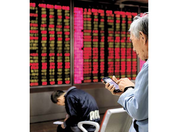 Inversionistas ven el tablero del mercado de valores de Pekín. 