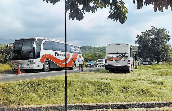 Dos autobuses y varios vehículos varados en una de las salidas del municipio michoacano. 