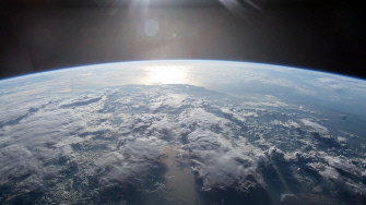  En esta imagen obtenida en la Estación Espacial Internacional de la NASA puede verse al sol reflejarse en el agua de la Tierra