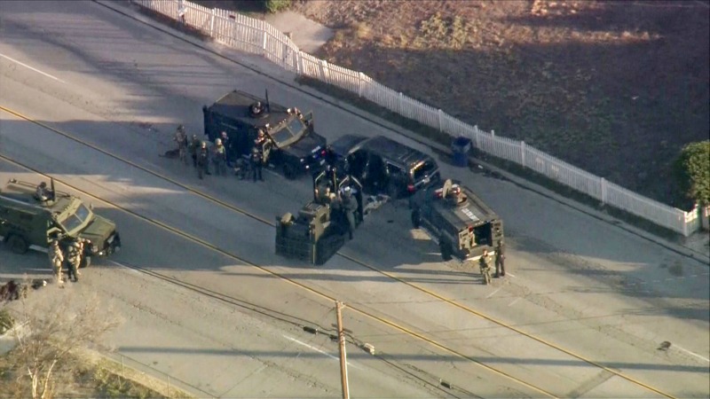 Vehículos blindados de la policía rodean la camioneta negra en la que huyeron los sospechosos del tiroteo en San Bernardino.