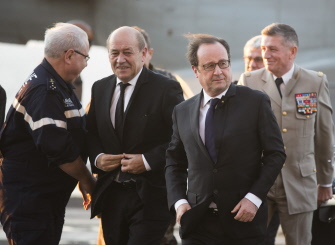 El ministro de Defensa francés, Jean-Yves Le Drian (2i), junto al presidente Francois Hollande (c) en el portaviones Charles de Gaulle