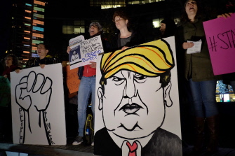 Activistas d y miembros de la comunidad musulmana muestran una pancarta con una caricatura de Trump en la manifestación en Nueva York