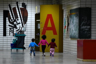 Niños refugiados caminan por los pasillos de un albergue para migrantes que buscan asilo en Berlín, Alemania