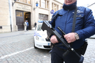 Un policía hace guardia ante una comisaría policial en Bruselas
