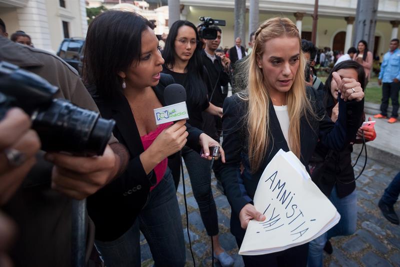 Lilian Tintori, esposa del líder opositor preso Leopoldo López, camina en las instalaciones de la Asamblea Nacional con una carpeta que tiene escrito 