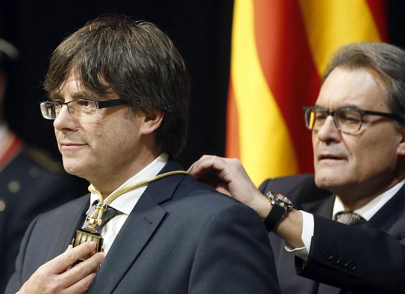 El ex presidente de la Generalitat, Artur Mas (d), impone la medalla representativa del cargo a su sucesor, Carles Puigdemont, el pasado martes