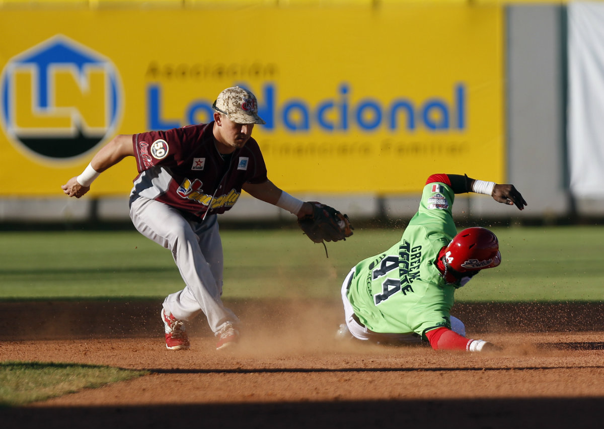 El jugador de Venados de Mazatlán Justin Greene es ponchado por Hernán Pérez (i), de Tigres de Aragua