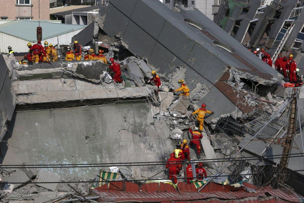 Personal de rescate busca víctimas entre los escombros de un edificio que colapsó en Tainan tras el sismo de 6.4 grados.