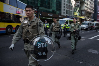 Policías antidisturbios de Hong Kong caminan junto a una calle bloqueada tras los disturbios de la noche, este martes en el distrito Mongkok