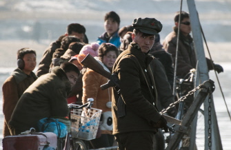 Un soldado norcoreano hace guardia en un barce en el río Yalu, cerca de la ciudad de Sinuiju, en la frontera con la ciudad china de Dandong 