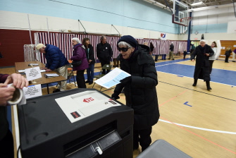 Una mujer vota durante las primarias en el gimnasio de una escuela en Concord, New Hampshire