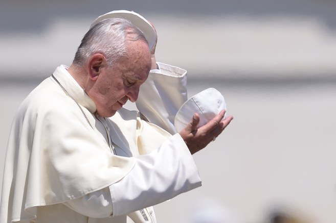 El papa Francisco se cambia el gorro durante una audiencia en la plaza de San Pedro, en Ciudad del Vaticano