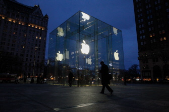 Un hombre camina junto a una tienda de Apple en la Quinta Avenida de Nueva York