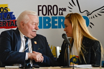 Lilian Tintori (d), la mujer del opositor encarcelado Leopoldo López, da la mano al ex presidente de Polonia, Lech Walesa, hoy en Caracas