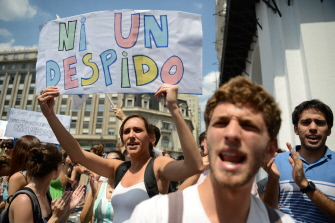 Un funcionario público muestra una pancarta contra los despidos en una manifestación contra el gobierno de Macri en el centro de Buenos Aires