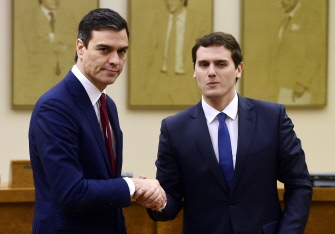 El líder socialista, Pedro Sánchez (i), da la mano a su par de Ciudadanos, Albert Rivera (d), tras firmar el acuerdo en el Congreso de Diputados